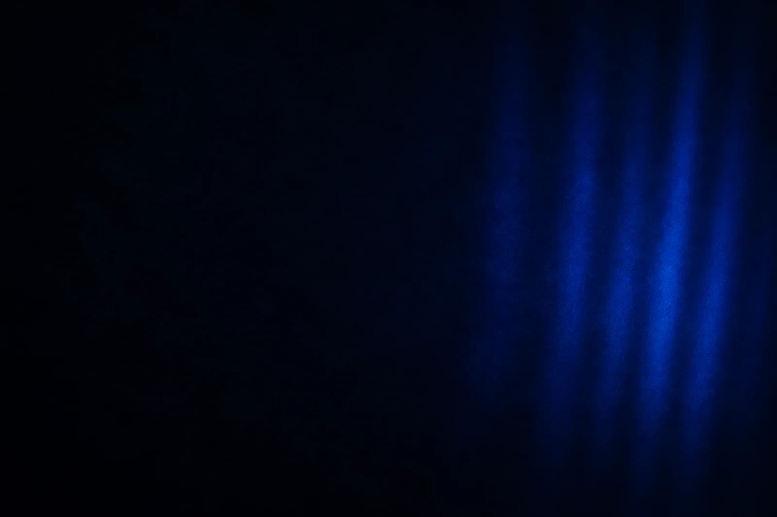 Dark light-texture website background with soft cobalt bands, inky depth, and a spacious left copy-safe field