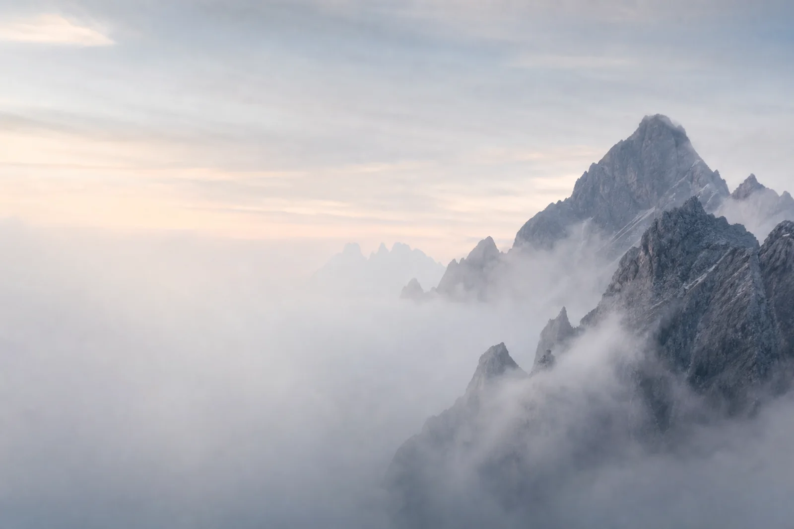 Premium editorial landscape background with sculptural alpine ridges, morning cloud, and misty left-side text space