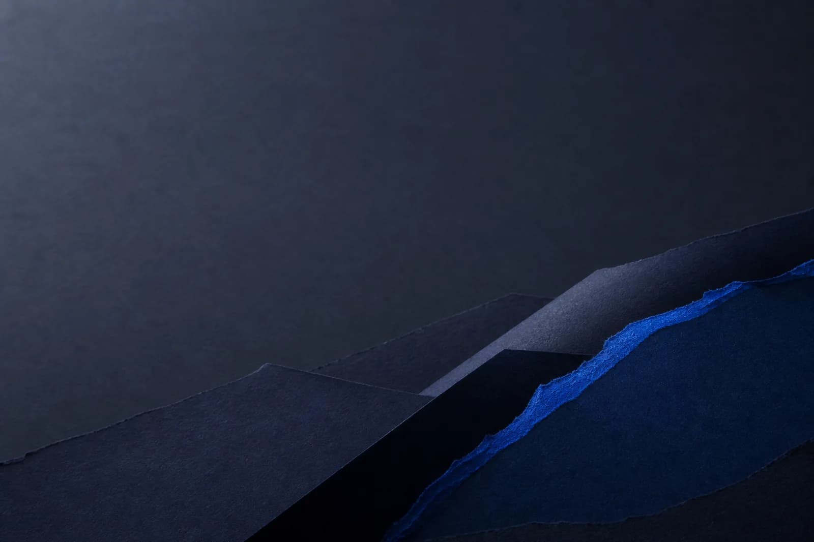 Premium dark paper background with layered indigo planes, a cobalt torn edge, and clear text-safe space