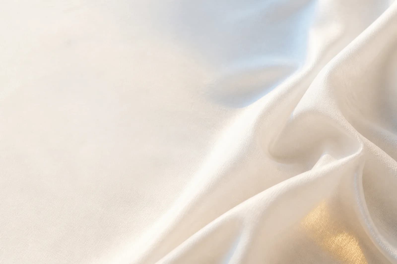 Premium light website background with softly folded cream textile, pale daylight, and a muted gold reflection